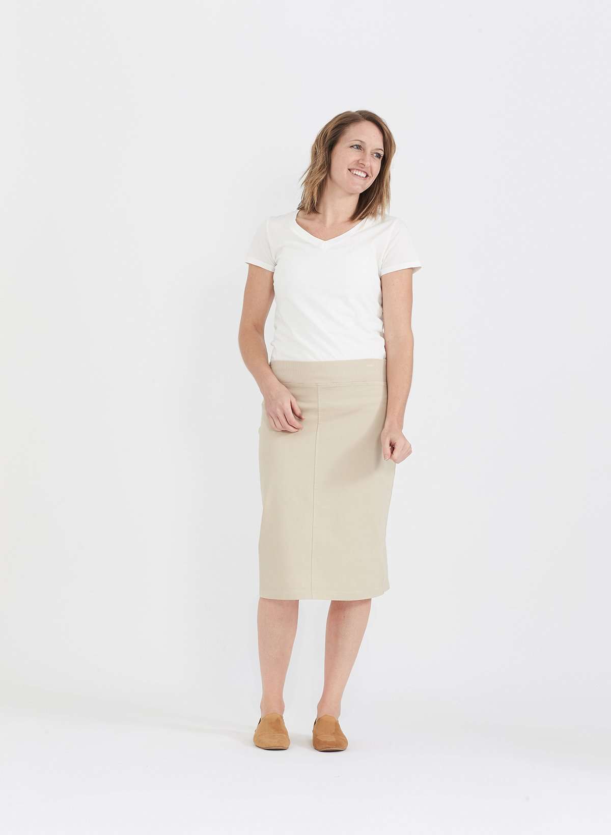 Woman wearing a colored, denim-like skirt with a elastic waistband. This is a modest skirt that falls below the knee. It comes in Burgundy, olive, khaki, black and navy. It is also paired with a white v-neck t-shirt.